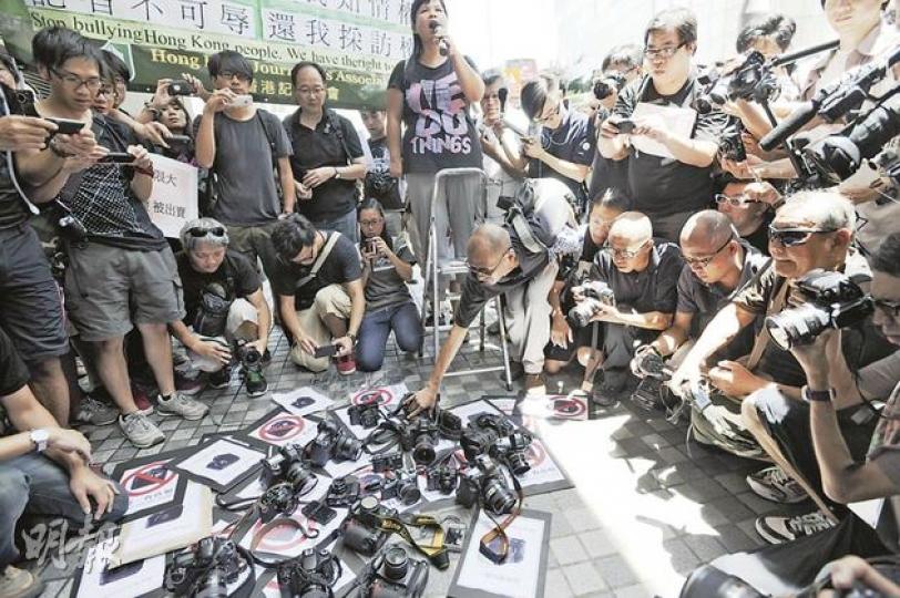 昨日參與遊行的攝影記者,在灣仔警察總部外把相機放在地上,抗議警方在李克強到訪期間,以不同方式阻撓拍攝,令記者「拍不到真相」,令市民知情權受損。(何家達攝)(明報製圖) 昨日參與遊行的攝影記者,在灣仔警察總部外把相機放在地上,抗議警方在李克強到訪期間,以不同方式阻撓拍攝,令記者「拍不到真相」,令市民知情權受損。(何家達攝)(明報製圖)