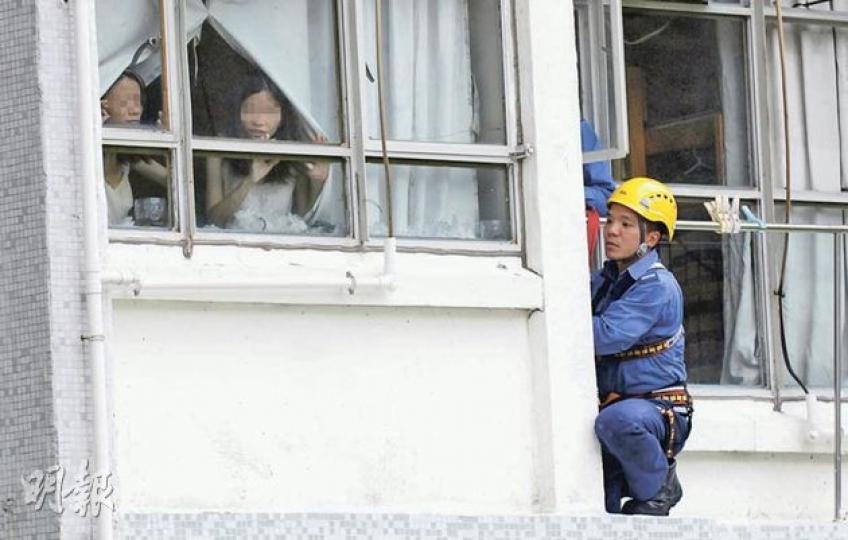 反鎖房內的姊妹花不時好奇窺探窗外情况,神態輕鬆;消防「飛將軍」則躲在外牆露台上謹慎戒備。(雲錦鋒攝) 反鎖房內的姊妹花不時好奇窺探窗外情况,神態輕鬆;消防「飛將軍」則躲在外牆露台上謹慎戒備。(雲錦鋒攝)