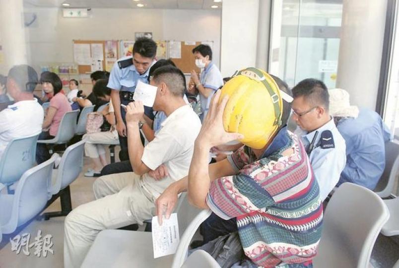 在新政府總部參與打鬥的工人,事後由警員押往醫院治理,看到記者拍照即掩面避開鏡頭。(雲錦鋒攝) 在新政府總部參與打鬥的工人,事後由警員押往醫院治理,看到記者拍照即掩面避開鏡頭。(雲錦鋒攝)