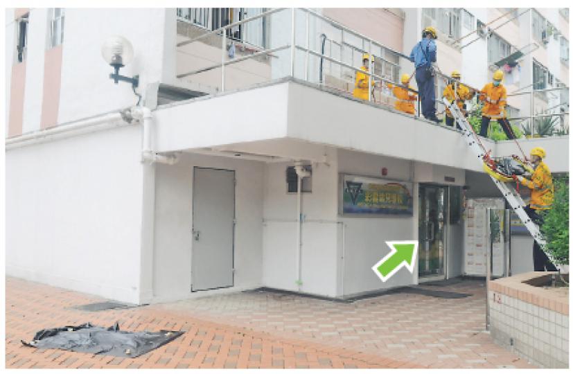 墮樓老婦跌在幼稚園前門(箭嘴示)簷篷上,一條腿飛脫跌在地上,消防員事後把屍體抬出。(蔡方山攝) 墮樓老婦跌在幼稚園前門(箭嘴示)簷篷上,一條腿飛脫跌在地上,消防員事後把屍體抬出。(蔡方山攝)