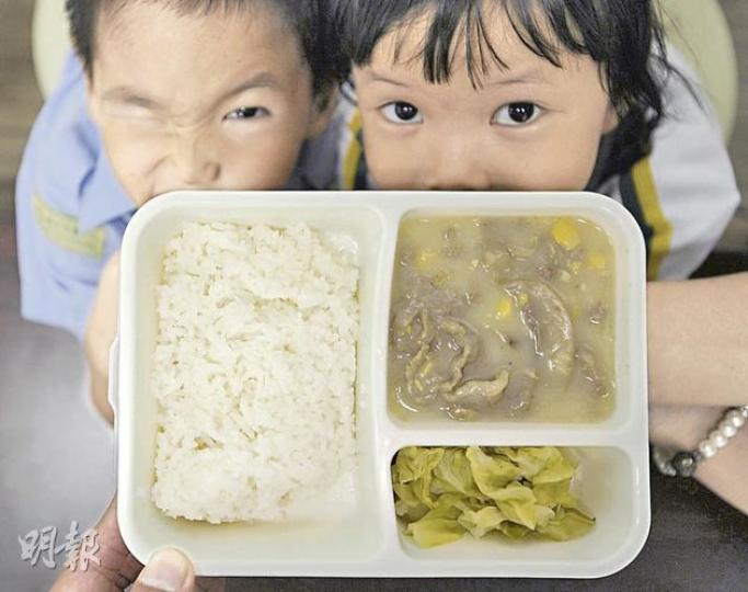 留意到基層巿民對食物需求增加，有社福機構在今年底將增設社區飯堂，提供十蚊一餐的價廉而有營養的食物。圖中的陳氏小兄妹與父親到現有的一間飯堂開餐，父親既可省錢，小朋友又能與飯堂內其他用膳者玩耍。（余俊亮攝）