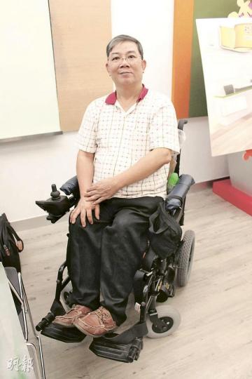 殘疾人士蕭東才指本港不少出入境口岸的櫃台太高，令他們難以與職員溝通及遞交文件。（邱雅錡攝）