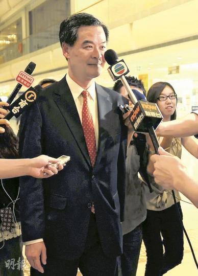 梁振英昨出席深水埗地區團體國慶活動，被記者追問如何看唐英年的「感情缺失」，其間有記者舉咪意外碰到他的臉。（何家達攝）