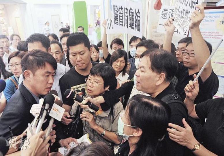 13歲男童張睿霆在屯門醫院手術後身亡，其父母（右下角戴口罩女士及身旁男士）昨日到醫院抗議，要求交代事故詳情，醫管局新界西聯網署理總監鍾健禮（左一）到場接信，其間張母情緒激動，一度拉扯着鍾健禮不放。（樊銳昌攝）