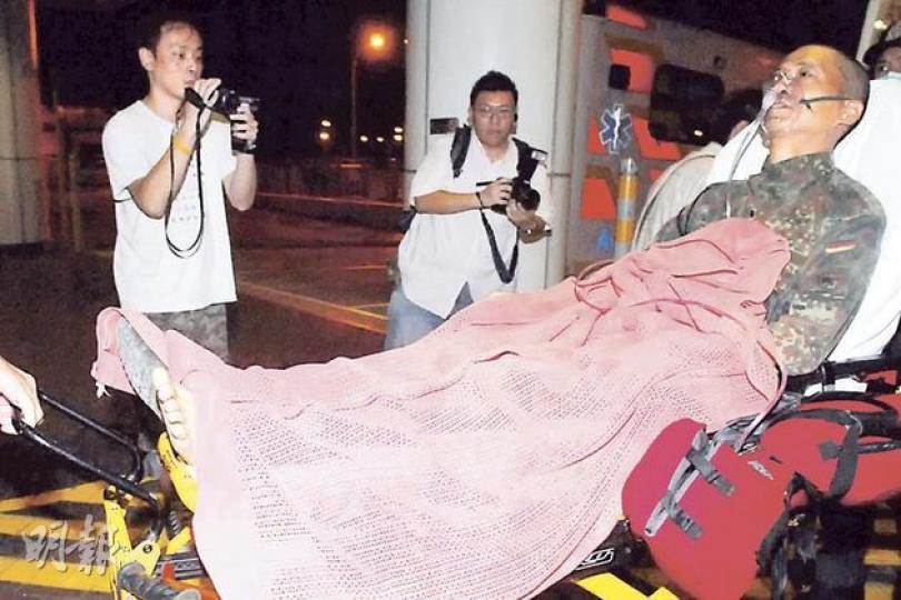 身穿迷彩服的中年漢，右腳掌內側被青竹蛇咬傷，需送院治理。（鍾炳然攝）