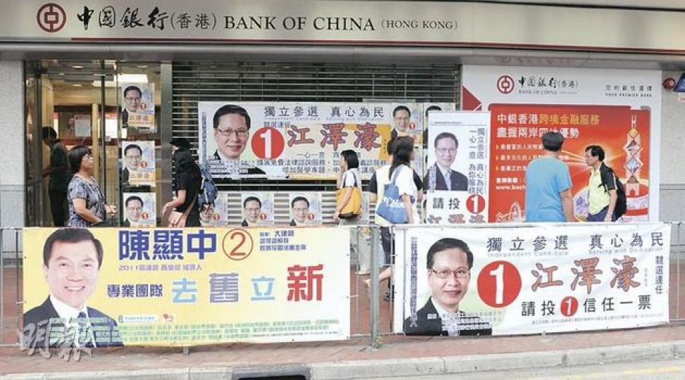 西灣河選區位於寶文大廈的中國銀行,昨日張貼着大量候選人江澤濠的宣傳海報及橫額,另一候選人陳顯中則在街上掛橫額。(劉焌陶攝) 西灣河選區位於寶文大廈的中國銀行,昨日張貼着大量候選人江澤濠的宣傳海報及橫額,另一候選人陳顯中則在街上掛橫額。(劉焌陶攝)