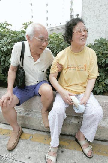 居於34樓的傅先生(左),扶着有腳患的愛妻沿樓梯走到地下逃生,兩人到樓下時仍緊緊相依。(黃雄攝) 居於34樓的傅先生(左),扶着有腳患的愛妻沿樓梯走到地下逃生,兩人到樓下時仍緊緊相依。(黃雄攝)