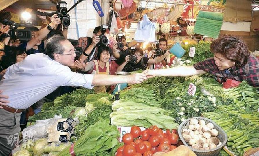 唐英年(左)昨到沙田正街街市,不少檔主均表示,不管誰當特首,能回應市民訴求便會支持。圖為唐與菜檔檔主「奮力一握」。(李澤彤攝) 唐英年(左)昨到沙田正街街市,不少檔主均表示,不管誰當特首,能回應市民訴求便會支持。圖為唐與菜檔檔主「奮力一握」。(李澤彤攝)