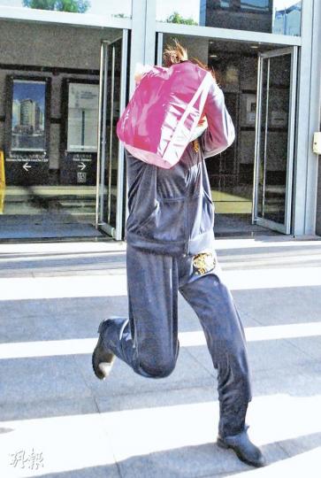 被男友打裂肋骨的女子,昨以膠袋遮面跑離法庭。(阮穎嘉攝) 被男友打裂肋骨的女子,昨以膠袋遮面跑離法庭。(阮穎嘉攝)
