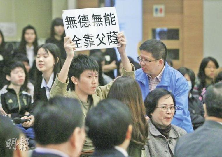 唐英年到訪期間,有恒管學生舉起「無德無能 全靠父蔭」諷刺標語,有校方人員(藍衣者)上前阻止。(林振東攝) 唐英年到訪期間,有恒管學生舉起「無德無能 全靠父蔭」諷刺標語,有校方人員(藍衣者)上前阻止。(林振東攝)