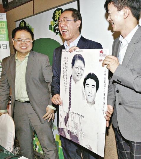 唐英年(中)接受主辦單位送贈的「惡搞」海報時,被問及海報上印有「傻仔」二字會否介意,唐搖搖頭,笑稱覺得網民「好有創意」。右為「網民力量」成員項明生。(李紹昌攝) 唐英年(中)接受主辦單位送贈的「惡搞」海報時,被問及海報上印有「傻仔」二字會否介意,唐搖搖頭,笑稱覺得網民「好有創意」。右為「網民力量」成員項明生。(李紹昌攝)