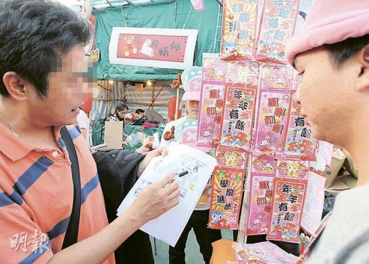 持有Hello Kitty和My Melody等熱門卡通商標的日本公司Sanrio的便衣法律代表（左），昨到維園年宵巡查盜版貨，其間向一個售賣盜版My Melody揮春的攤檔東主（右）發出口頭警告。（李澤彤攝）