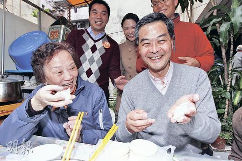 特首參選人梁振英(右)批評唐英年不願和他同場辯論,又引港台節目《城市論壇》為例,指論政不必先待政綱出台。圖為他昨日到荃灣二陂坊探訪,和住戶一起包餃子。(李紹昌攝) 特首參選人梁振英(右)批評唐英年不願和他同場辯論,又引港台節目《城市論壇》為例,指論政不必先待政綱出台。圖為他昨日到荃灣二陂坊探訪,和住戶一起包餃子。(李紹昌攝)
