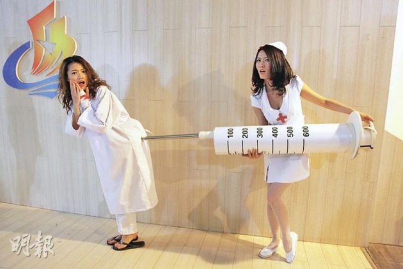 徐潔兒（右）將巨型針筒拮周秀娜（左）的pat pat。（攝影﹕娛樂組）