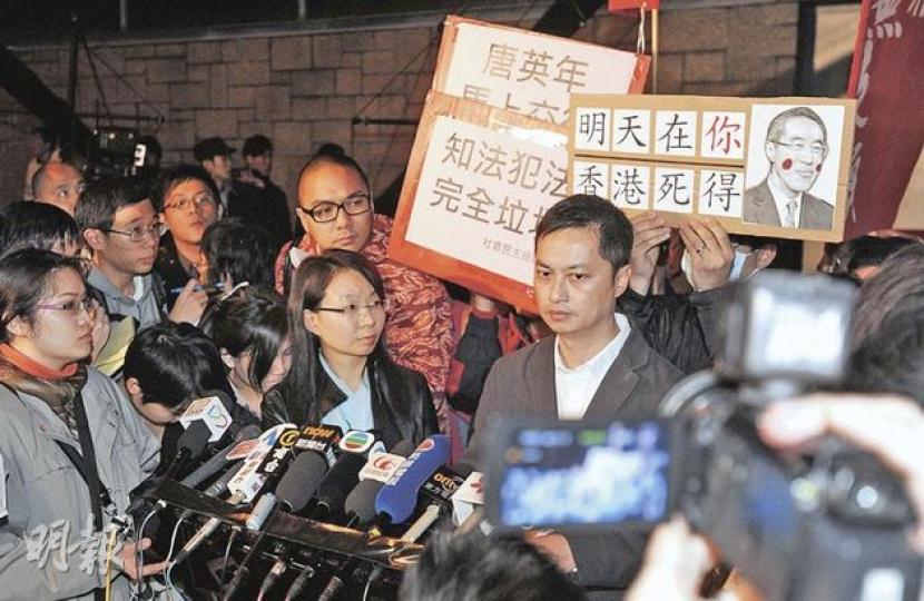 屋宇署高級屋宇測量師高翹建(右)與同僚視察唐宅3個多小時後,在記者和示威者包圍下交代巡視結果,親證唐宅停車場下,隱藏一個面積達2250平方呎的巨型僭建地庫。(余俊亮攝) 屋宇署高級屋宇測量師高翹建(右)與同僚視察唐宅3個多小時後,在記者和示威者包圍下交代巡視結果,親證唐宅停車場下,隱藏一個面積達2250平方呎的巨型僭建地庫。(余俊亮攝)