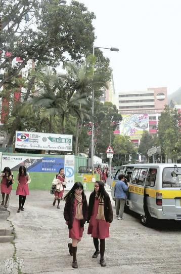 警方昨早偕勞工處於瑪利曼小學校門外,拘捕一名正接送該校小學生上學的黑工保母。(林錫禮攝) 警方昨早偕勞工處於瑪利曼小學校門外,拘捕一名正接送該校小學生上學的黑工保母。(林錫禮攝)