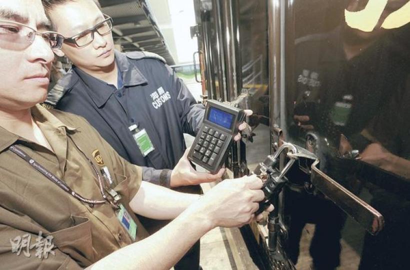 透過電子鎖通關技術,清關程序可大大簡化,抵達機場出境關口時,海關人員(右)可藉手提裝置解鎖抽驗。(尹錦恩攝) 透過電子鎖通關技術,清關程序可大大簡化,抵達機場出境關口時,海關人員(右)可藉手提裝置解鎖抽驗。(尹錦恩攝)