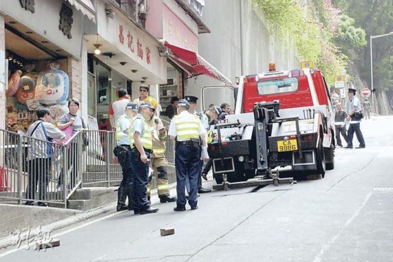 意外後警員在拖車（圖）附近調查，地上確留下兩枚相信是用來固定故障吊臂車車輪的木塊。（雲錦鋒攝）