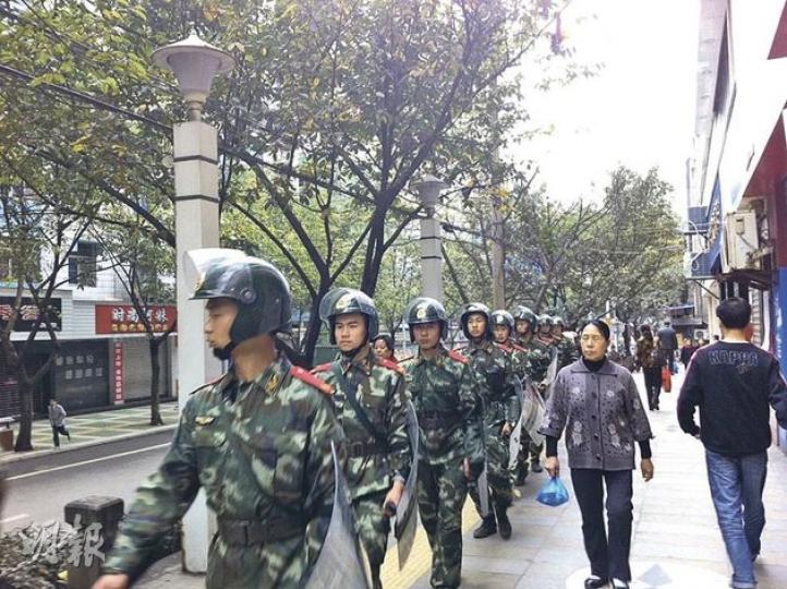 在重慶萬盛區，昨日街頭仍有大批武警列隊巡邏。（明報記者攝）
