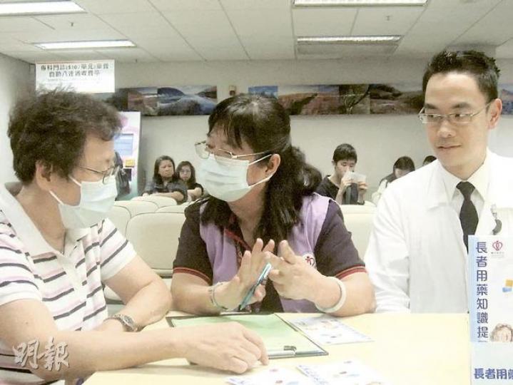 瑪麗醫院自2008年起推行長者用藥提升計劃，義工於取藥處主動接觸有需要的長者，以問卷調查服藥習慣，並將有嚴重服藥問題的長者轉介至臨牀藥劑師跟進。圖中為義工吳女士，右為瑪麗醫院臨牀藥劑師黃兆賢。（黎嘉愉攝）