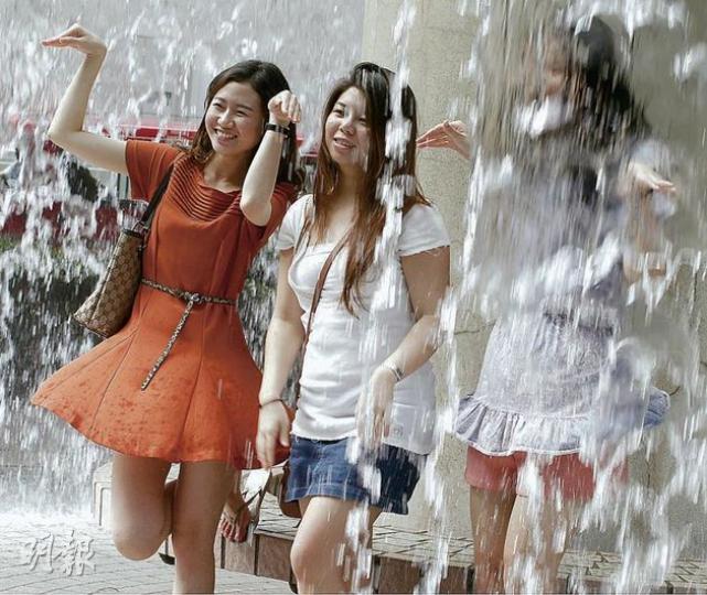 天文台昨發出今年首個酷熱天氣警告，在氣溫高逾30℃下，不少市民外出時均穿著淺色短衫短褲，亦有市民趁機到香港公園嬉水。（李紹昌攝）
