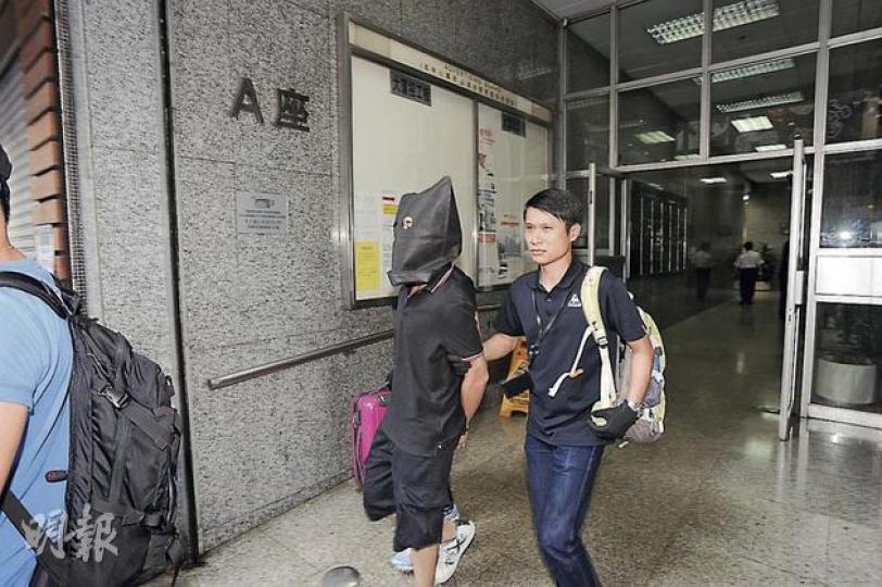警方拘捕涉嫌製毒的18歲疑犯，用黑布蒙頭及戴上手銬將他押返警署扣查。（樊銳昌攝）