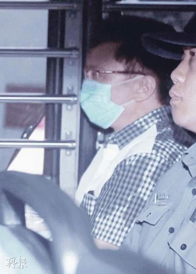 劉定成昨穿上前面白色、後面黑白格仔的恤衫，戴上口罩，由囚車押往法庭。（林振東攝）