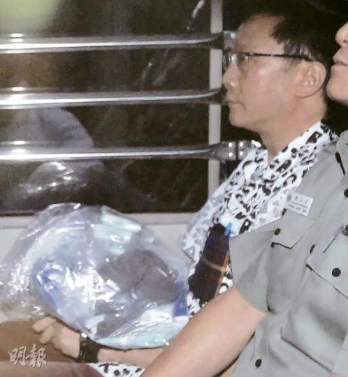 被判監17個月的劉定成，昨換上花紋恤衫，平靜由囚車押走。（李紹昌攝）