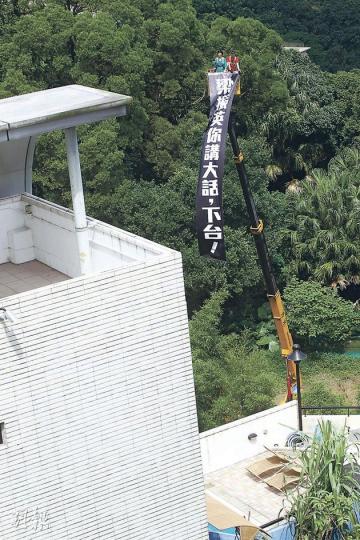 民主黨昨在梁振英山頂大宅外，以1800元租用吊臂車，將寫上「梁振英你講大話，下台！」的25呎長布條掛起，以示抗議。（李紹昌攝）