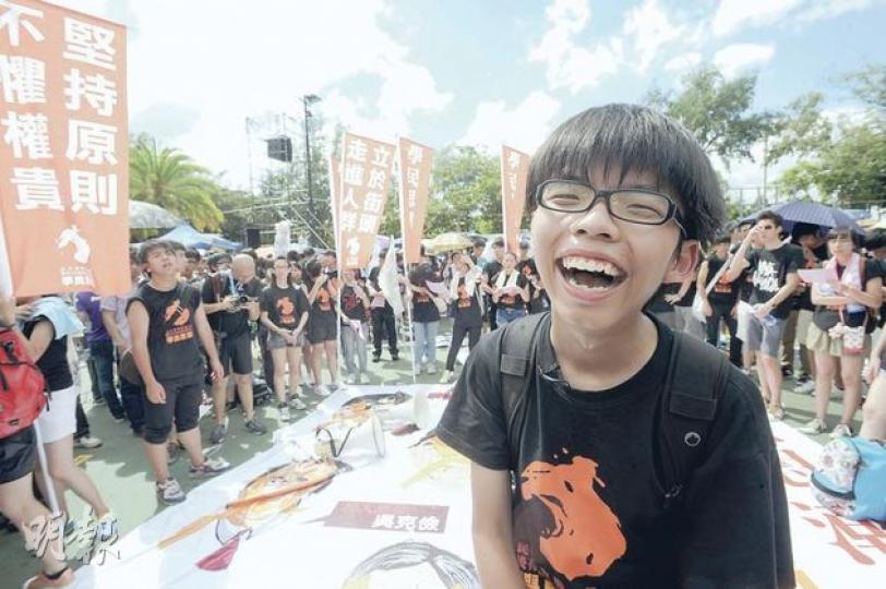 第二次統籌中學生參加七一遊行的黃之鋒，今年號召約400名中學生上街，較去年成立中學生組織「學民思潮」時，號召人數增一倍。他與幾名負責人一早便出發準備各種用品擺街站，下午在維園耐性地等候多個小時才出發，無懼炎熱天氣，一隊人至晚上8時才到達添馬艦政府總部。（尹錦恩攝）