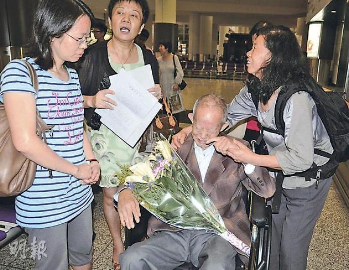 王文金(坐輪椅者)由妻子黃亞珍(右)及女兒用輪椅推出香港機場時,老淚縱橫,港商內地投資權益關注組召集人陸偉萍(左二),則獻上一束鮮花慰問。(明報記者攝) 王文金(坐輪椅者)由妻子黃亞珍(右)及女兒用輪椅推出香港機場時,老淚縱橫,港商內地投資權益關注組召集人陸偉萍(左二),則獻上一束鮮花慰問。(明報記者攝)