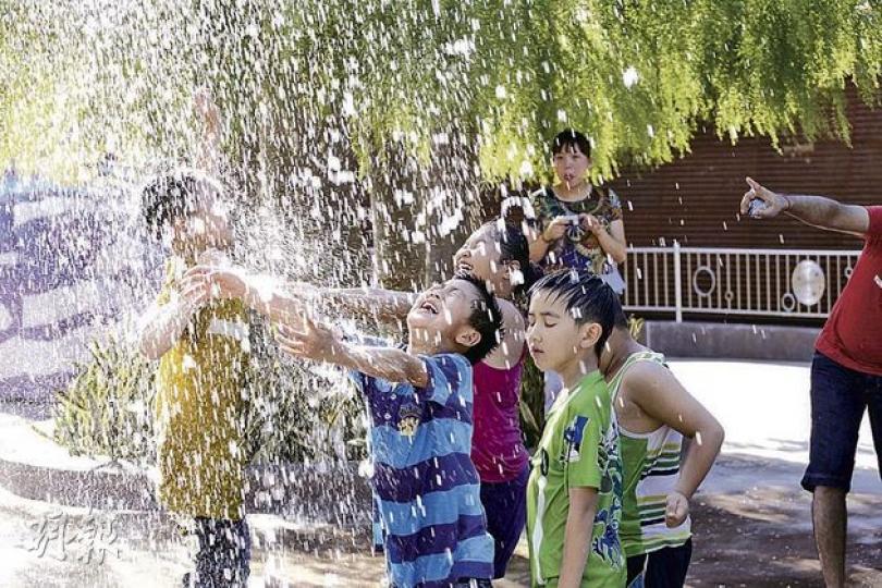 昨日天氣炎熱，部分時間氣溫高達33℃，到迪士尼遊玩的市民亦大汗淋漓，一眾小朋友抵受不了高溫，跑到噴水遊樂設施玩水消暑。天文台昨日發出酷熱天氣警告，今日日間天氣亦會持續酷熱，最高氣溫33℃。（李紹昌攝） 烈日當空，在迪士尼內遊玩的小朋友，看見樂園設施上有流水流動，即把臉貼上消暑，狀甚享受。（李紹昌攝）