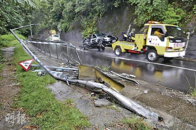 大埔公路3車相撞意外中,一大段路邊鐵欄被掃毁,疑強行切線爬頭惹禍的私家車嚴重損毁,意外後由拖車拖走。(林錫禮攝) 大埔公路3車相撞意外中,一大段路邊鐵欄被掃毁,疑強行切線爬頭惹禍的私家車嚴重損毁,意外後由拖車拖走。(林錫禮攝)