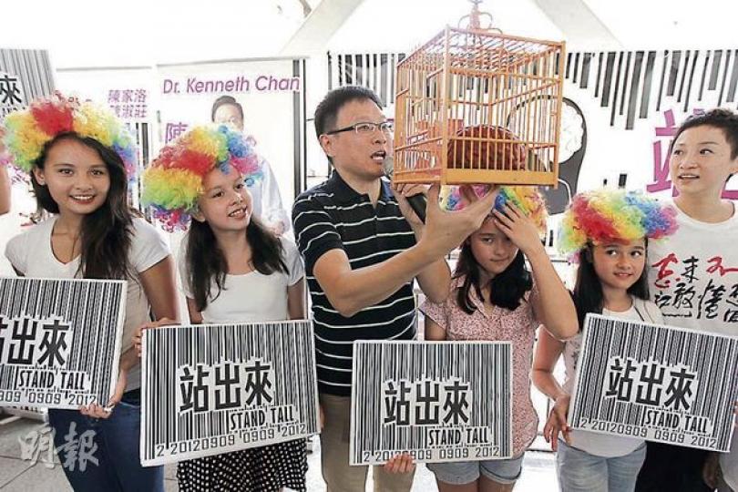 公民黨陳家洛(左三)和陳淑莊(右一)昨日籲市民參與反國民教育科遊行。陳家洛的4名女兒戴上假髮,代表小朋友的世界多姿多彩,陳拿着一個鳥籠,當中困着一個被染紅了的道具腦,代表洗腦式國民教育規限小朋友的健康成長。(李紹昌攝) (明報製圖) 公民黨陳家洛(左三)和陳淑莊(右一)昨日籲市民參與反國民教育科遊行。陳家洛的4名女兒戴上假髮,代表小朋友的世界多姿多彩,陳拿着一個鳥籠,當中困着一個被染紅了的道具腦,代表洗腦式國民教育規限小朋友的健康成長。(李紹昌攝) (明報製圖)