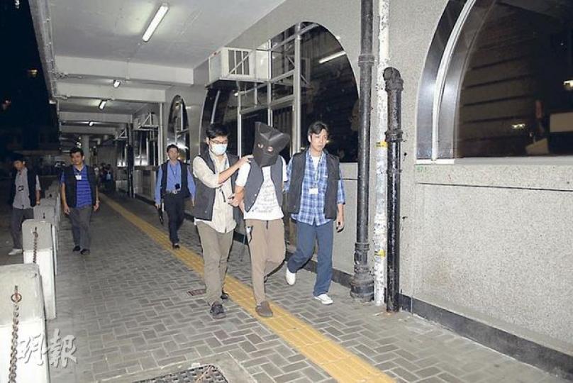 東九龍總區重案組探員昨晚把涉嫌淋腐蝕液傷人的疑犯押返寶琳邨寓所搜查。(伍浦鋒攝) 東九龍總區重案組探員昨晚把涉嫌淋腐蝕液傷人的疑犯押返寶琳邨寓所搜查。(伍浦鋒攝)