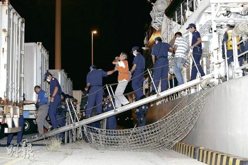 啟豐二號船長楊匡等9人,昨晚被押返沖繩那霸新港,移送至沖繩警署,眾人下船時均被扣上手銬,再被綁上粗繩,由日方人員前後牢牢看守。部分保釣成員下船時高叫「打倒日本軍國主義」等口號,其中羅堪就(圖中)更高喊「一定會再返嚟」。(李澤彤攝) 啟豐二號船長楊匡等9人,昨晚被押返沖繩那霸新港,移送至沖繩警署,眾人下船時均被扣上手銬,再被綁上粗繩,由日方人員前後牢牢看守。部分保釣成員下船時高叫「打倒日本軍國主義」等口號,其中羅堪就(圖中)更高喊「一定會再返嚟」。(李澤彤攝)