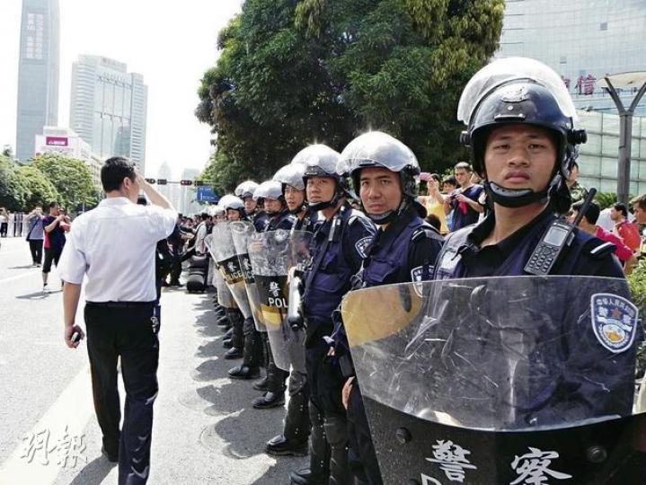 大批警員手持盾牌在深圳深南大道中信廣場的吉之島前戒備。(明報記者攝) 大批警員手持盾牌在深圳深南大道中信廣場的吉之島前戒備。(明報記者攝)