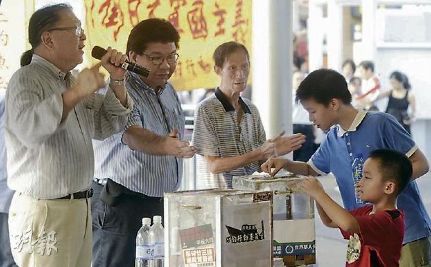 保釣行動委員會昨日在尖沙嘴天星碼頭設立街站募捐,吸引不少途人及遊客圍觀及捐款,當中不乏小孩子。(余俊亮攝) (明報製圖) 保釣行動委員會昨日在尖沙嘴天星碼頭設立街站募捐,吸引不少途人及遊客圍觀及捐款,當中不乏小孩子。(余俊亮攝) (明報製圖)