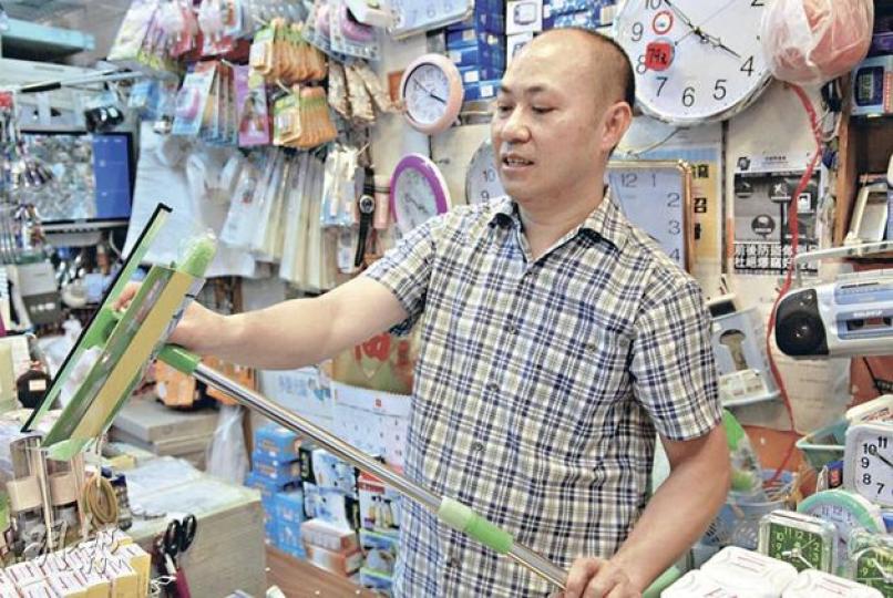 觀塘區山貨店老闆劉先生提醒市民，抹窗切勿拆窗花，建議市民若抹窗時不夠高，可購買其手中約售35元的伸縮棍抹窗，以策安全。（伍浦鋒攝）