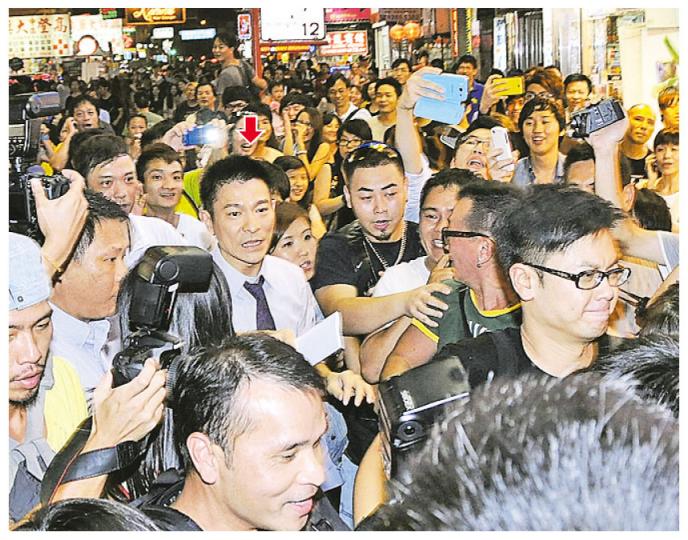 華仔出現時被大批市民包圍，幾經辛苦才能跟大隊會合。（攝影/記者：梁榮達） 鄭秀文雙手拿着多袋外賣，又要邊行邊講電話，似乎有點狼狽。（攝影/記者：梁榮達）