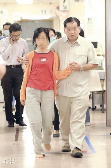 去年8月痛失愛兒的鄭妙華，昨一度把自己、女兒及外傭反鎖屋內，被救出後送院，赤腳的她偕夫離開醫院時稱，只望盡快召開死因庭尋回公道。（樊銳昌攝）