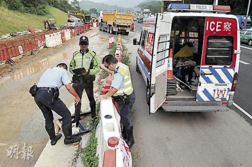 交通警模型昨首天「出勤」，其在吐露港公路所駐守位置外的400米剛巧發生一宗交通意外，事後警方將意外車輛拖到「交警」附近調查，其後順道安排「交警收工」，由同僚將模型搬上警車。（衛永康攝）