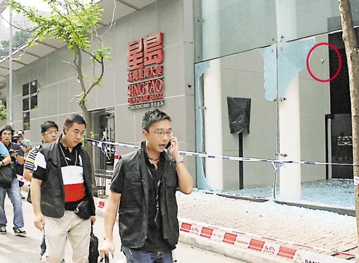 星島新聞集團大廈被兇徒駕車撞毁玻璃外牆，港島總區重案組昨午派出多名探員蒐證，檢走錄影帶及向職員錄口供，逗留個多小時後離去。大廈的閉路電視（紅圈示）對正被車撞毁的玻璃，相信有可能拍下案發經過。（雲錦鋒攝） 兇徒偷車駛到星島集團在筲箕灣的大廈，撞毁大樓玻璃後，將車駛到九龍灣放火燒車，警員事後到場調查。（蔡方山攝）