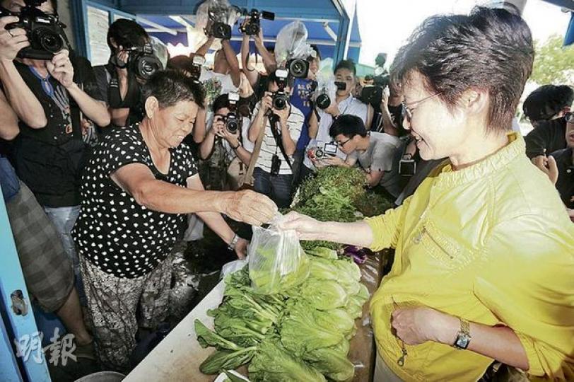 政務司長林鄭月娥（右）昨巡視錦上路跳蚤市場，即場光顧菜販。她說天水圍墟市既可提供廉價商品，也可參考錦上路發展成為假日市場。（尹錦恩攝）政府將天水圍天秀路3.8萬平方呎政府空置土地，免費批給東華三院營辦墟市，預計可提供約200個廉租攤檔。（尹錦恩攝）