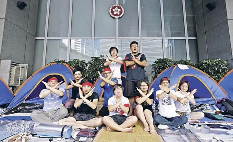 「一日不撤回、一日不撤走！」10名大學生、家長、教師及退休教師在政府總部外接力絕食，要求撤回國教科。前排左起﹕教協副會長黃克廉，城大學生陳德運、熊婉婷及詹玟玟，理大前副教授何芝君，國民教育家長關注組發言人黃瑞紅；中排左起﹕學聯常委會主席鄧永威、教協理事韓連山；後排左起﹕學聯秘書長李成康、城大學生李澤民。（李澤彤攝） 梁振英（右二）昨晚出席《鏡報》月刊晚宴後首次回應萬人集會反國教科一事，他稱知道有市民反對國教科的決心，而反對理由是「怕洗腦」，但政府沒這意圖，亦無這樣的做法。右一為梁太唐青儀。（鄧宗