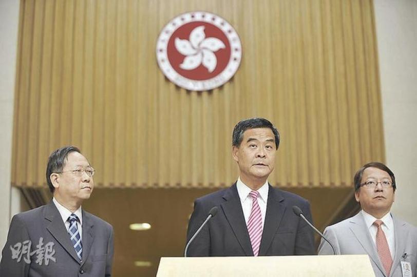 行政長官梁振英（中）昨與保安局長黎棟國（左）及入境處長陳國基（右）宣布內地暫緩擴大一簽多行，他否認這是為國民教育降溫。（葉家豪攝）