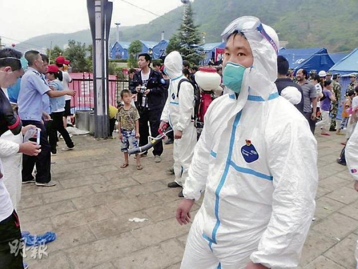 防疫人員到災區噴灑消毒藥水，防止疫情發生。（李泉攝）