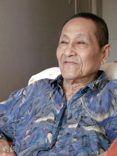 現年80歲的鮑彤身形瘦削，右眼年初時一度失明，現時觀看物件也時有吃力，但思維敏捷。（明報記者攝） 鮑彤（前右）家中掛有他1996年出獄不久拍的全家福，一家人難得再聚。（明報記者翻攝）