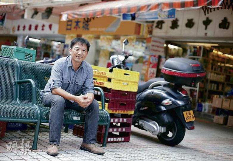 扎根九東的胡志偉，拍照期間不時與街坊打招呼，附近商舖負責人亦祝賀他當選。（李澤彤攝）