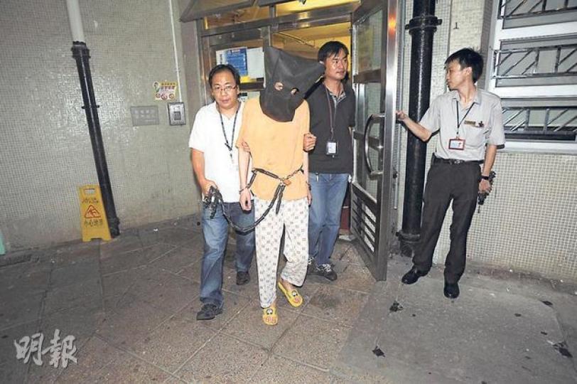 涉嫌謀殺被捕的56歲男子，昨晚被警方鎖上鐵鏈、黑布蒙頭押返天耀邨寓所蒐證。（樊銳昌攝）